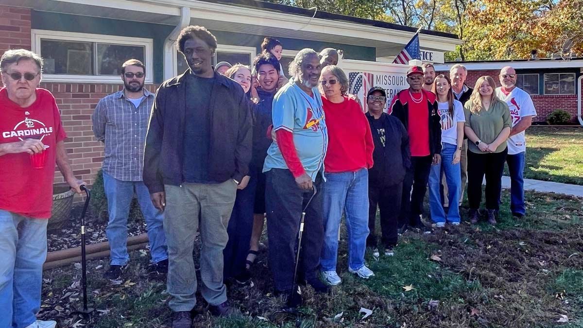 Group of veterans, their families, volunteers and staff in front of the MOVE sign