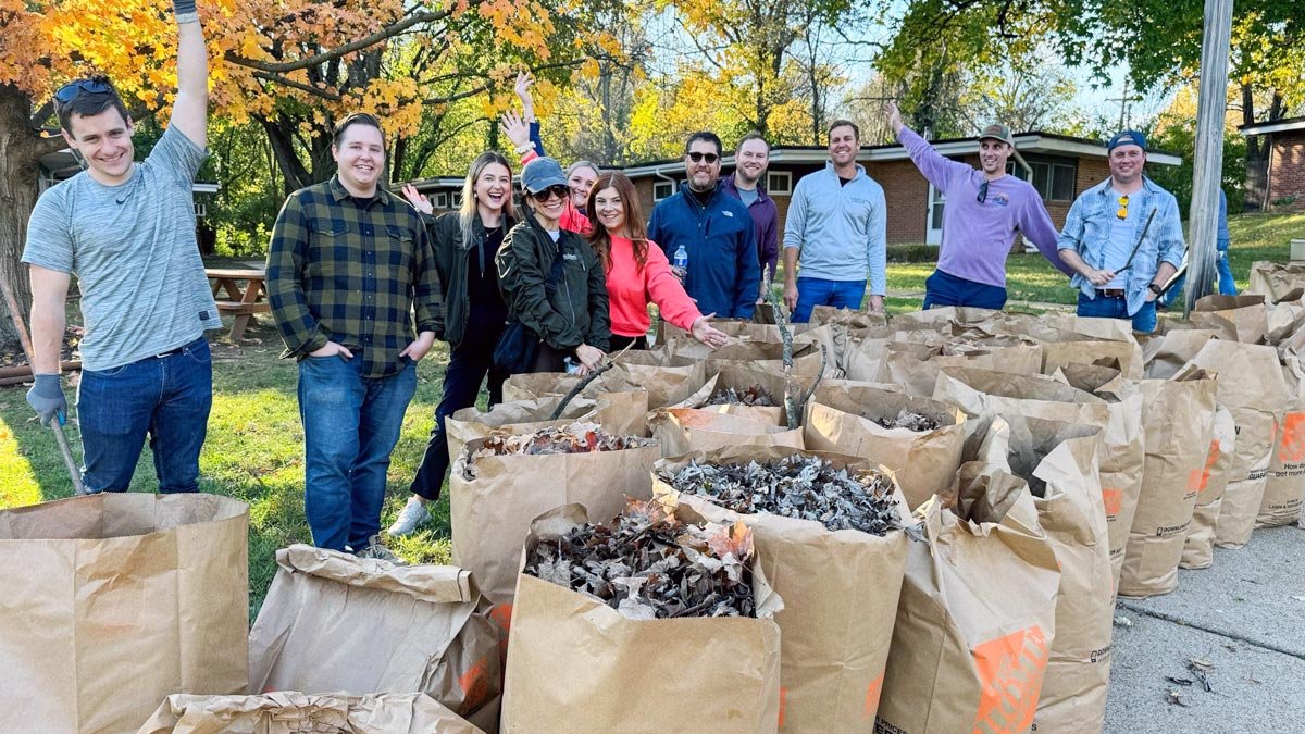 Group of volunteers with bags of leaves outside the MOVE residence